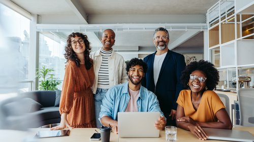 professionl group at computer smiling_iStock-2148674008