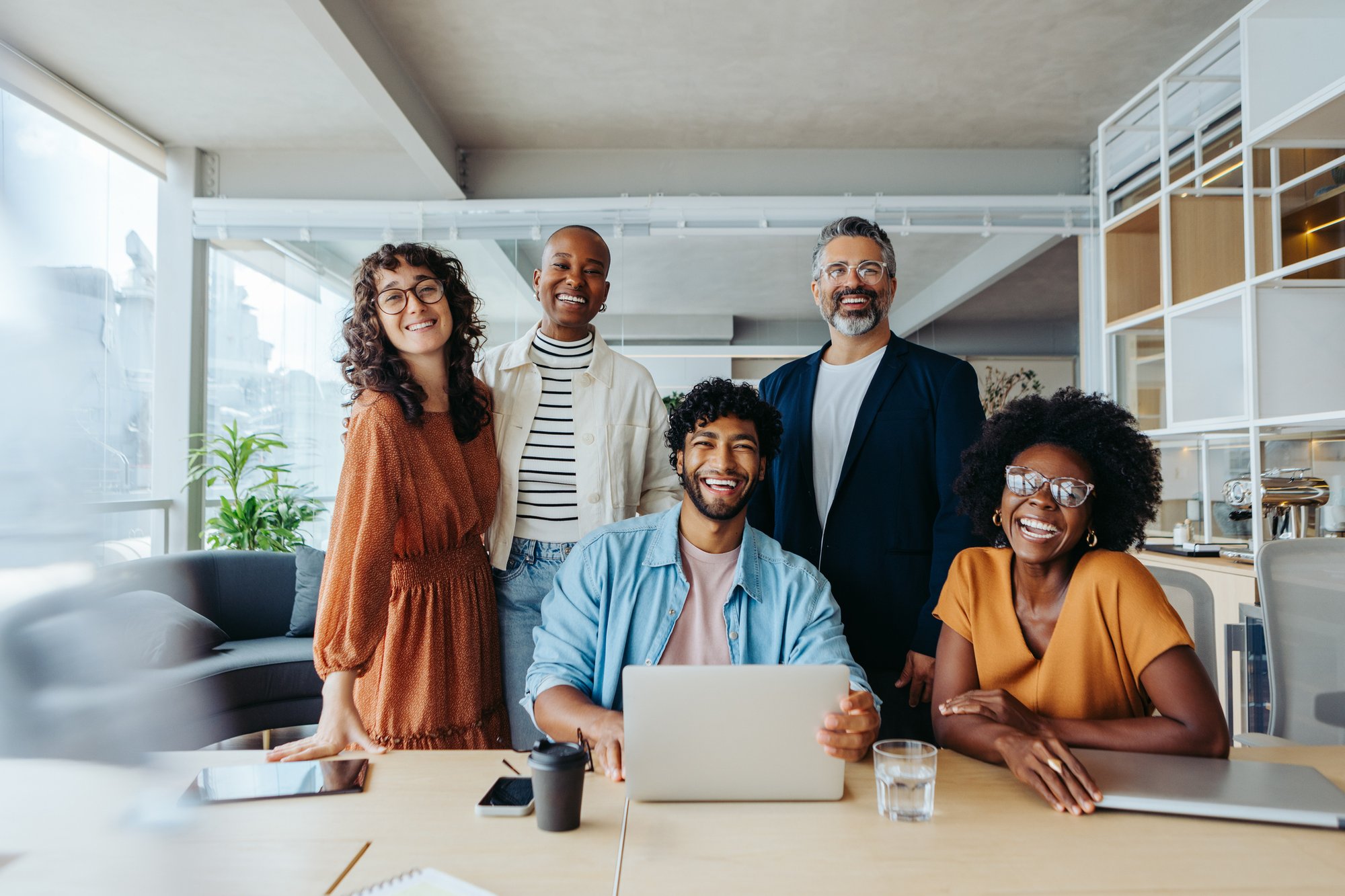 professionl group at computer smiling_iStock-2148674008